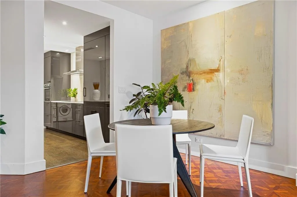 Parquet wood-finish flooring, recessed lighting, and a kitchen featuring integrated appliances, sleek cabinetry, and a stainless steel range hood