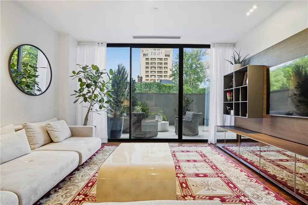 Full-height glass panels open to an outdoor patio space