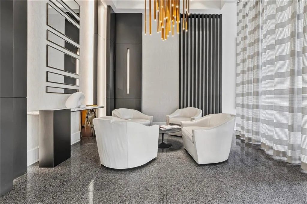 Terrazzo flooring, contemporary wall lighting, vertical slat accent wall, linear pendant lighting, and a console table with mirror accents