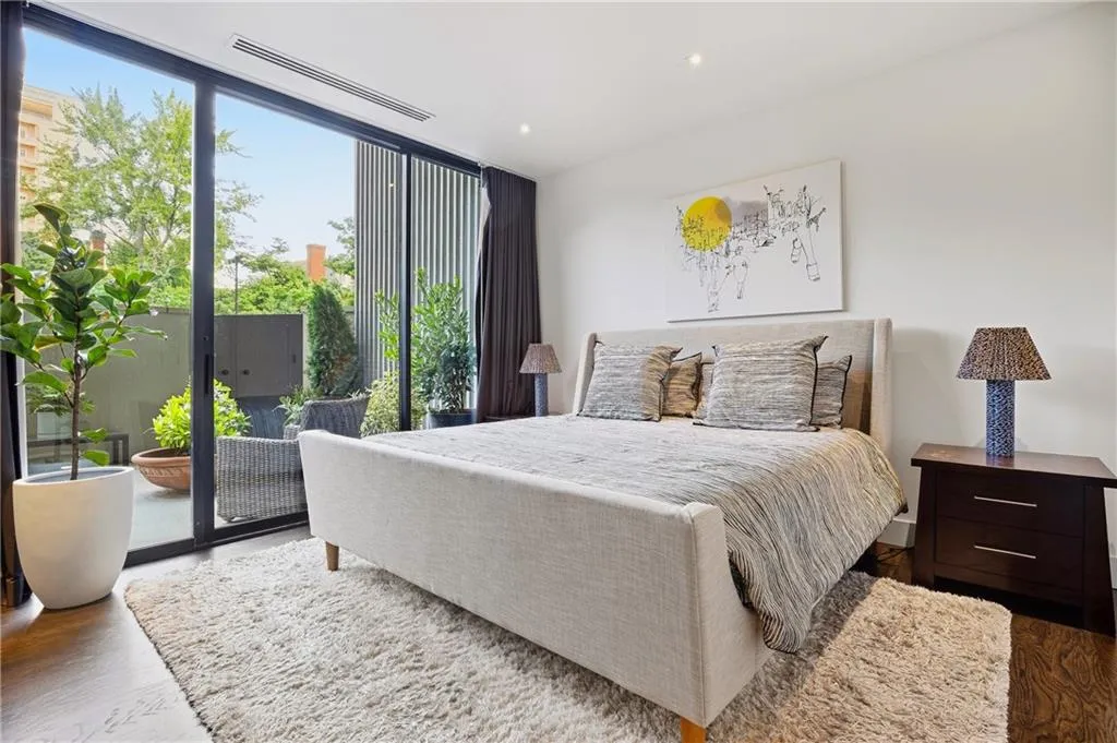 Expansive sliding glass doors, recessed lighting, wood-finish flooring, and a private outdoor patio