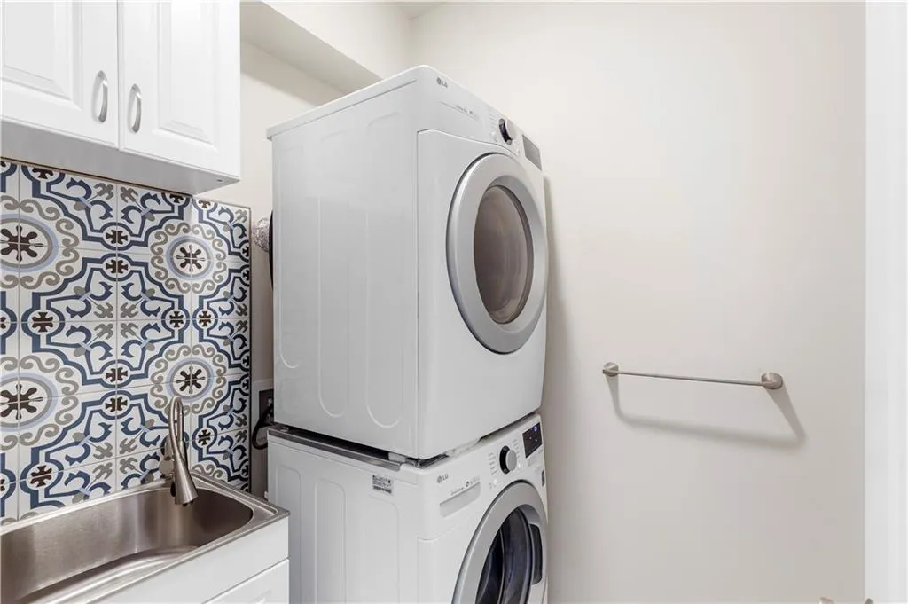 Laundry area with stacked washer / drying machine and cabinet space