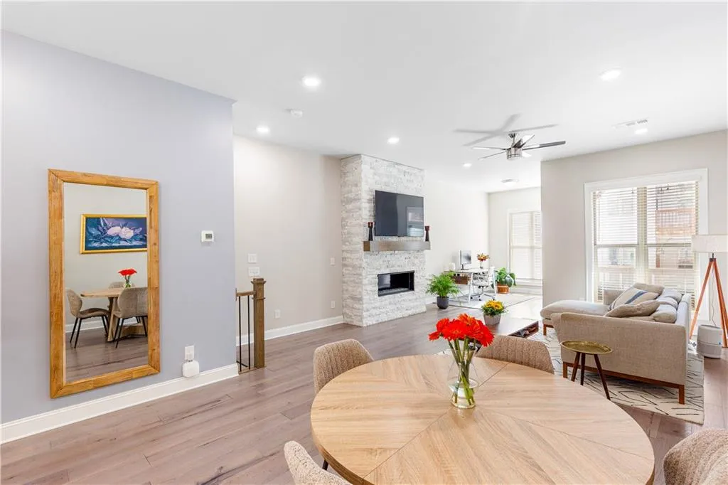 Dining room with ceiling fan, wood finished floors, recessed lighting, and a fireplace