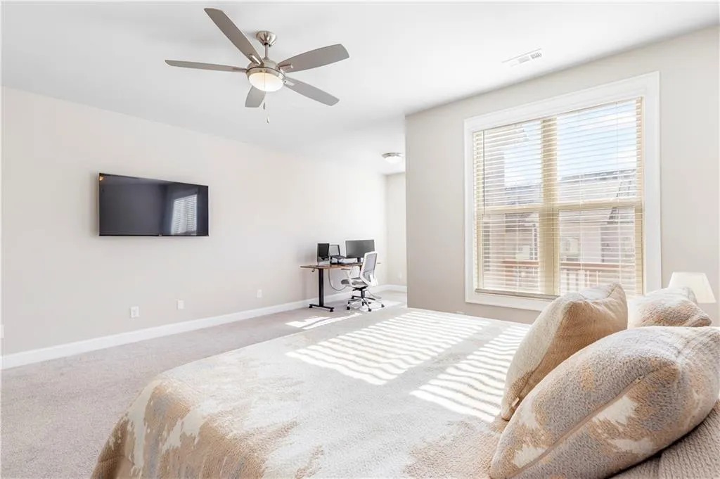 Bedroom with a desk, ceiling fan, and carpet