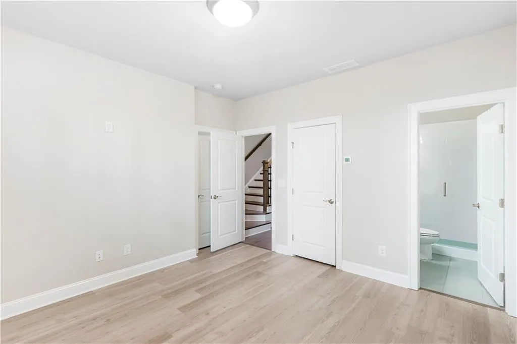 Unfurnished bedroom featuring light wood-style flooring and ensuite bath