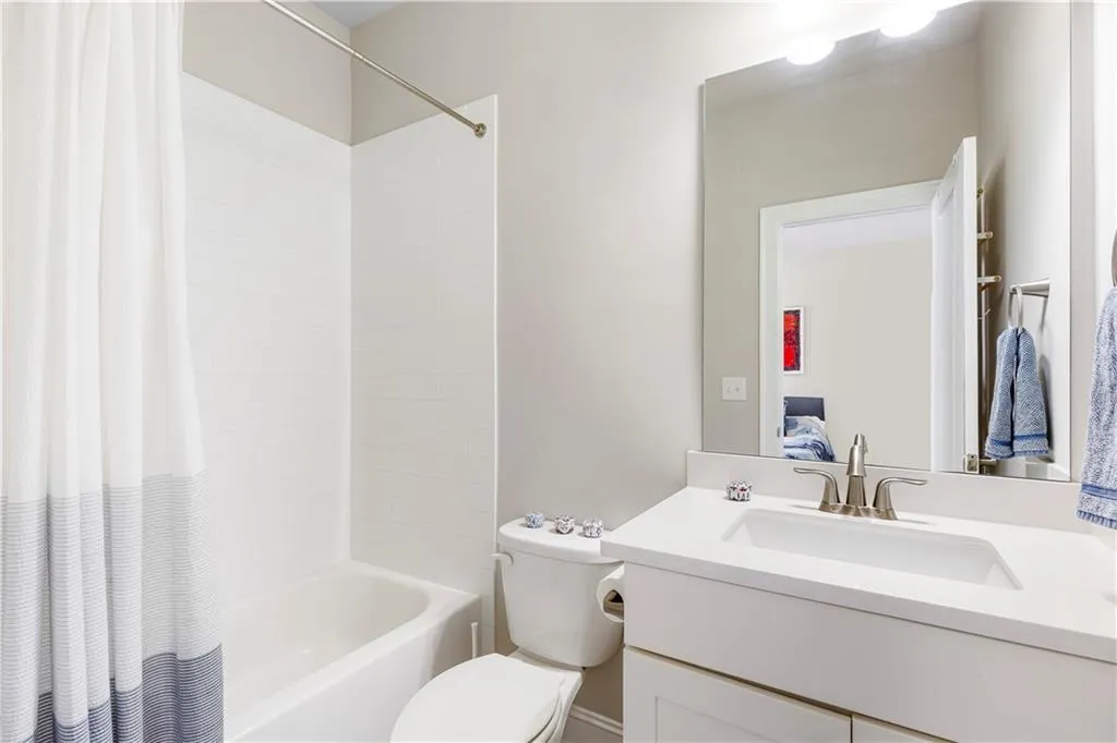 Bathroom featuring shower / bath combo, vanity, and connected bathroom