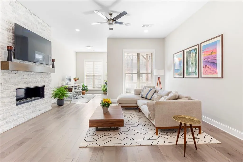 Living room featuring a fireplace, light wood-type flooring, ceiling fan, and recessed lighting