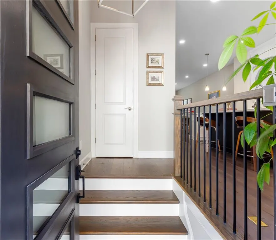 Stairway with wood finished floors and recessed lighting