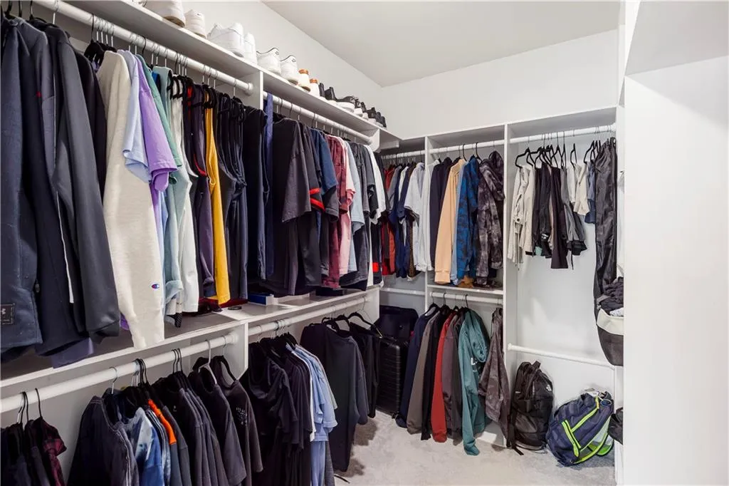 Walk in closet with light colored carpet