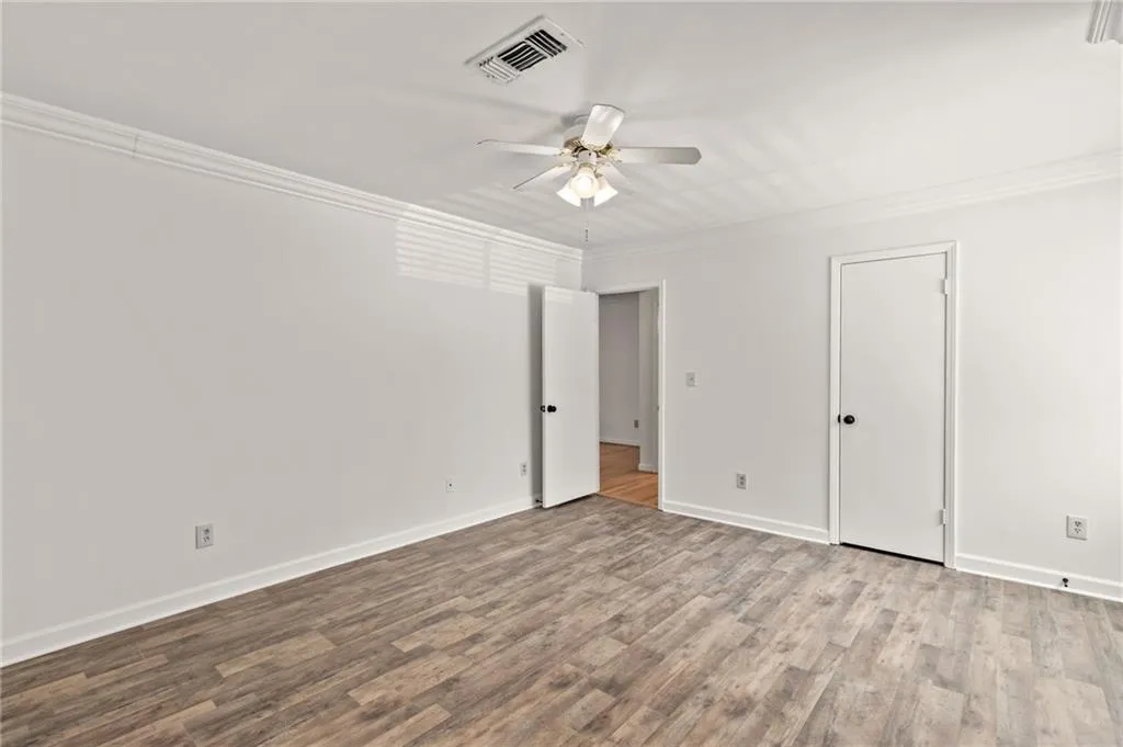 Unfurnished room featuring crown molding, light hardwood / wood-style flooring, and ceiling fan