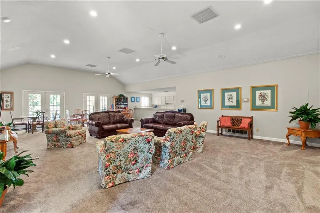 Living room with lofted ceiling, light carpet, and french doors