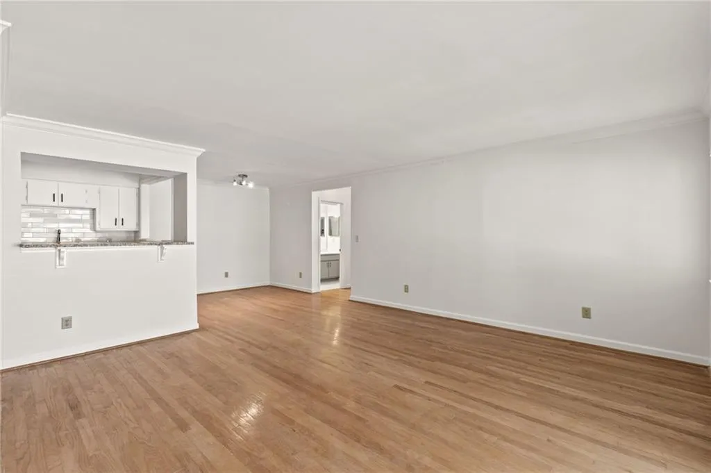 Unfurnished living room featuring crown molding and light hardwood / wood-style floors