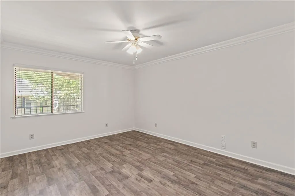 Spare room featuring ceiling fan, ornamental molding, and dark hardwood / wood-style floors