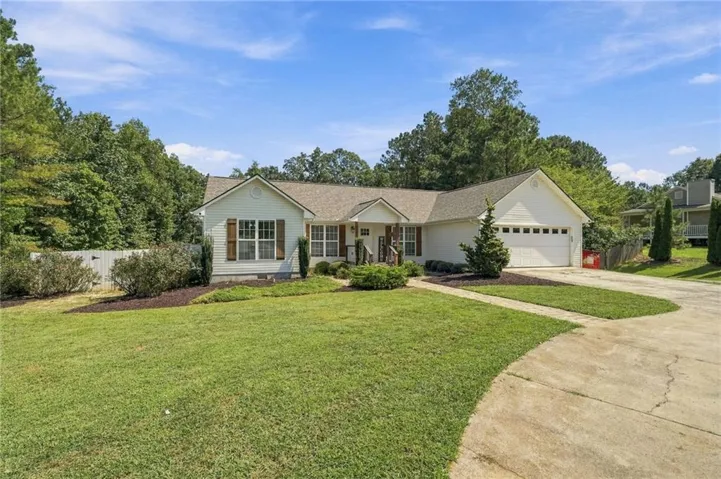 Single-story residence featuring a two-car garage, front porch, and mature landscaping
