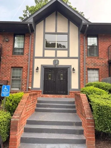 Brick exterior facade with a prominent gabled entrance featuring a large central window