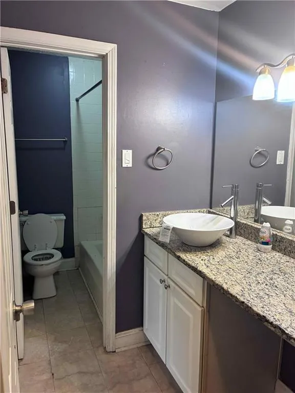 Full bath on second level featuring vanity, light tile patterned floors, and shower / tub combination
