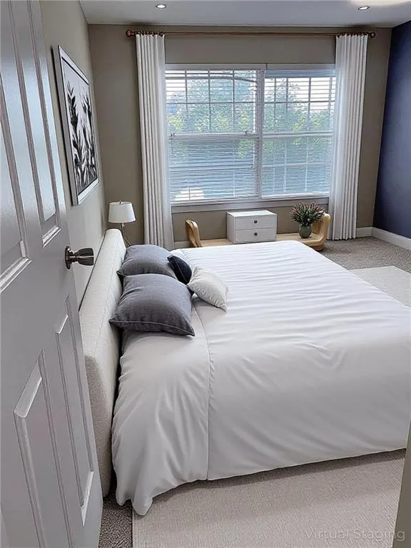 VIRTUALLY STAGED: Bedroom 2 featuring light colored carpet and baseboards