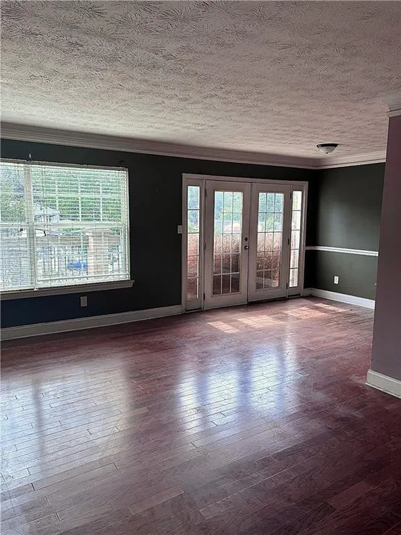 Dining room with ornamental molding, a textured ceiling, and wood-type flooring
