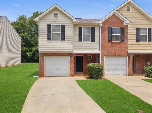 Exterior showcasing a combination of brick and siding, featuring multiple windows with dark shutters