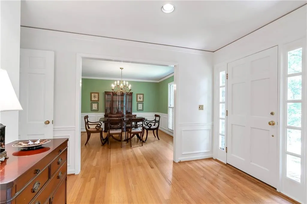 Entrance foyer featuring a notable chandelier, light hardwood / wood-style floors, and crown molding