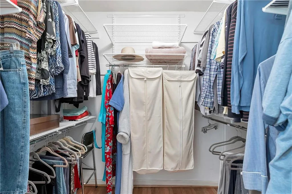 Walk in closet with hardwood / wood-style flooring
