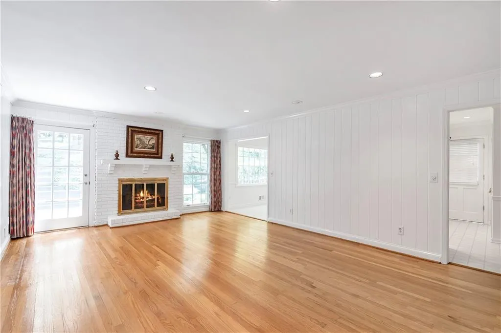 Unfurnished living room with crown molding, light tile floors, and a brick fireplace