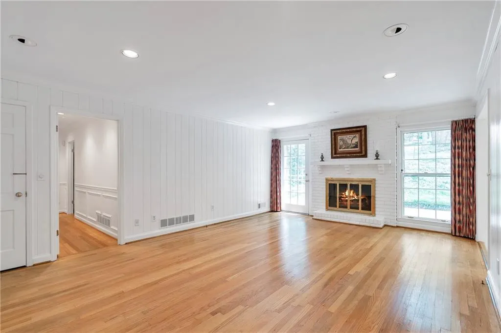 Unfurnished living room with light hardwood / wood-style floors, a fireplace, and crown molding