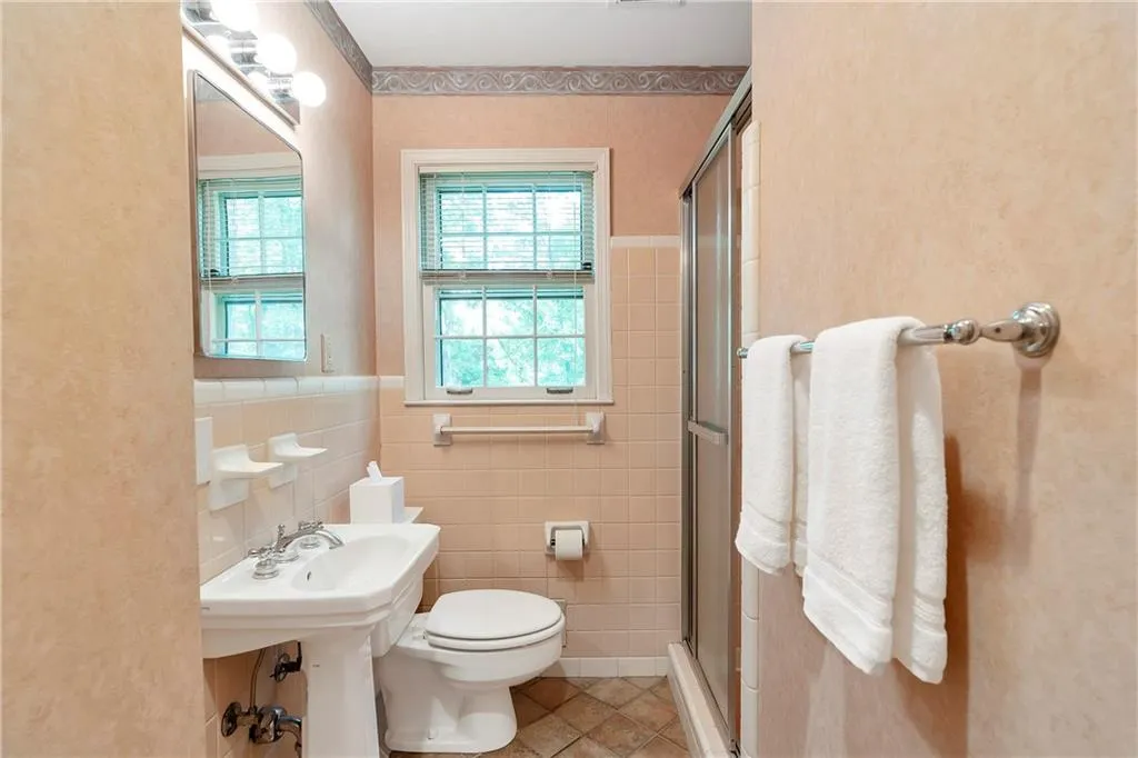 Bathroom featuring tasteful backsplash, an enclosed shower, tile walls, tile floors, and toilet