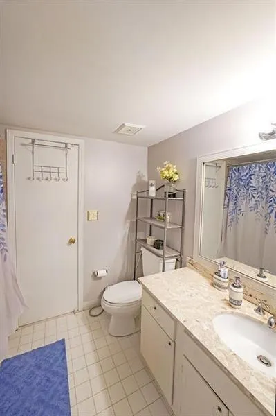 Bathroom featuring curtained shower, vanity, and light tile patterned floors