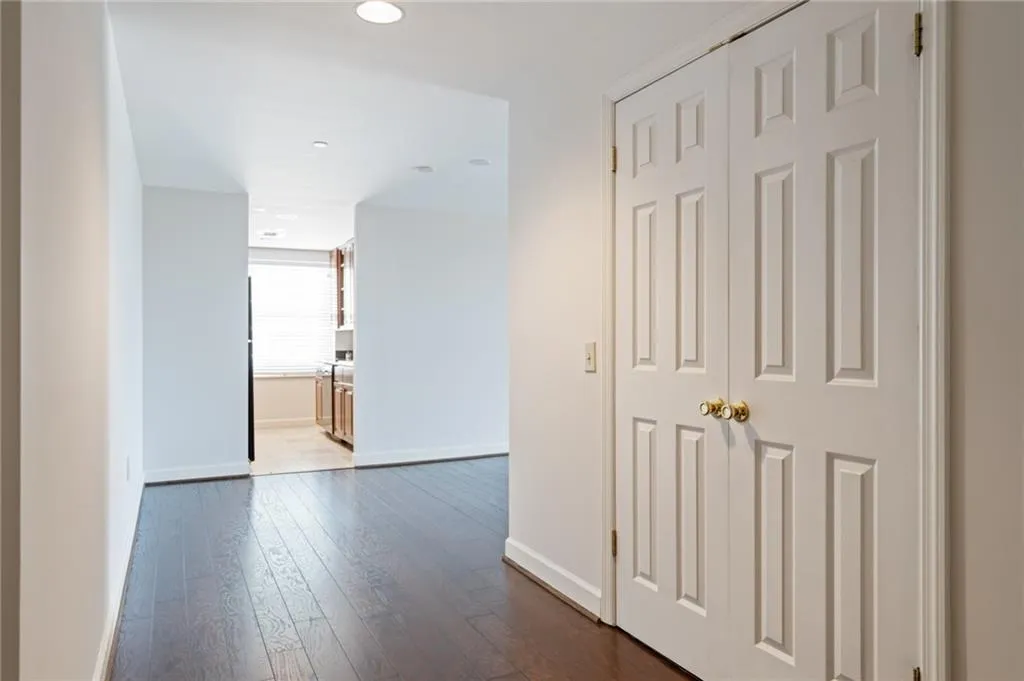 White paneled bi-fold doors with brass hardware compliment the wood-finish flooring
