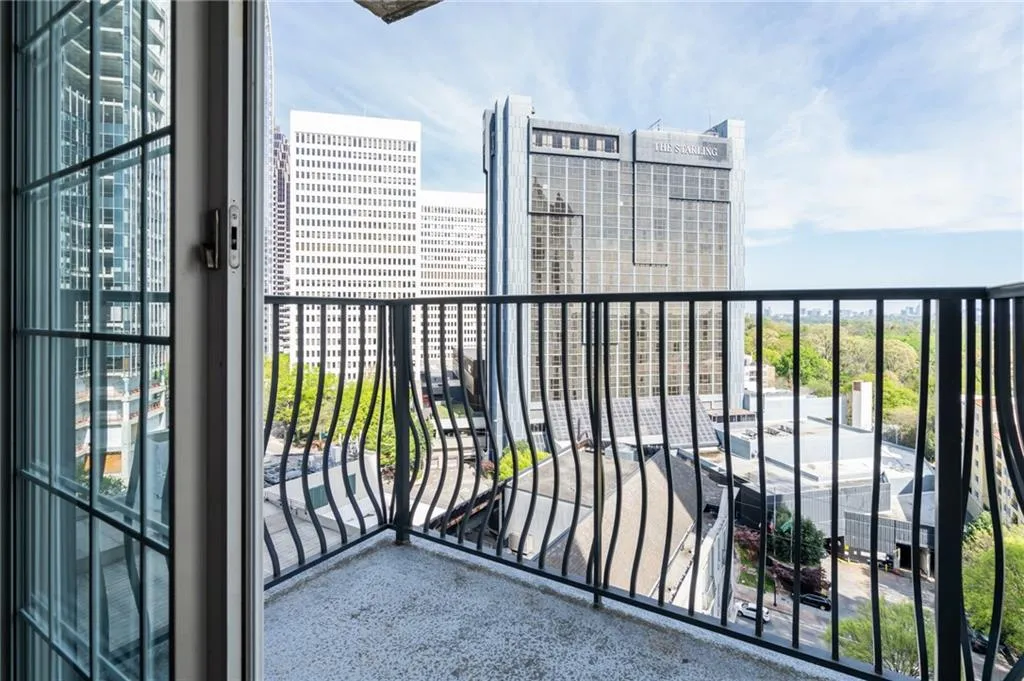 Balcony featuring a concrete surface and decorative wrought iron railing