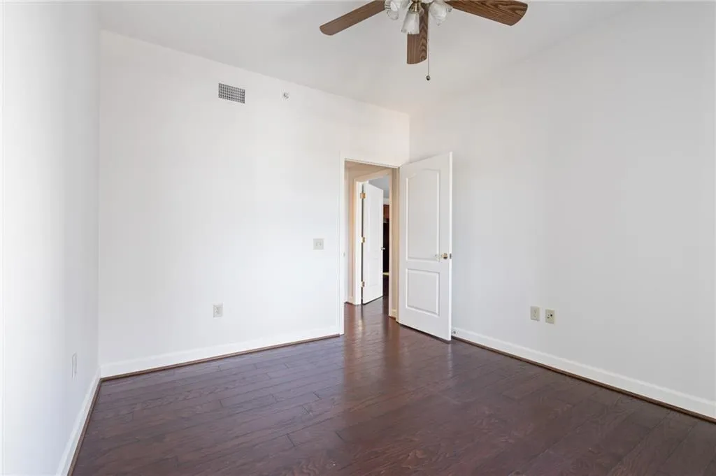 Room with wood-finish flooring, white walls, and white trim