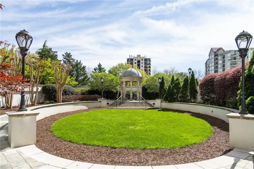 Circular lawn area featuring a central gazebo, surrounding shrubbery, mature trees, and decorative lampposts