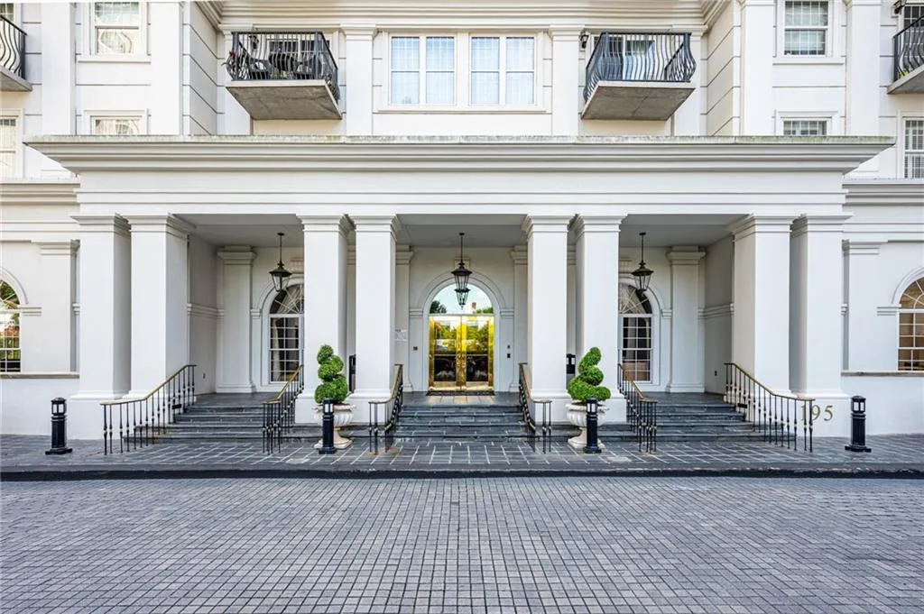 Grand architectural entrance featuring prominent white columns and a central arched doorway