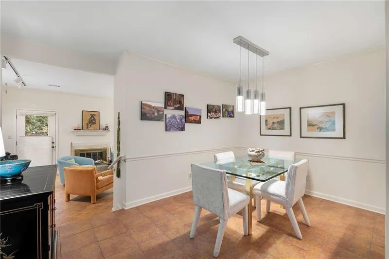 Dining room with crown molding, track lighting, a glass covered fireplace, a chandelier, and baseboards