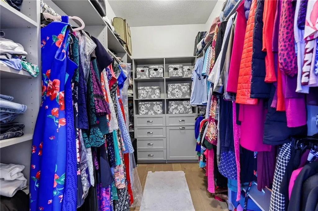 Large primary closet with custom finishes.