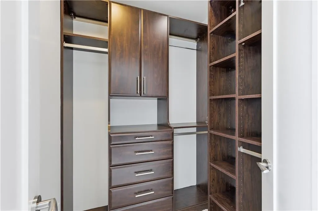 Custom closet system featuring dark wood-finish cabinetry