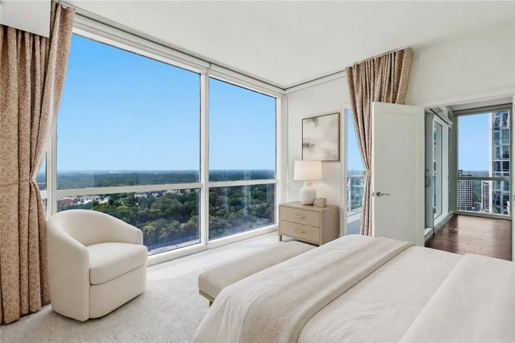 VIRTUALLY STAGED-Floor-to-ceiling windows, light-toned carpeting, and a glass-paneled door leading to an outdoor space