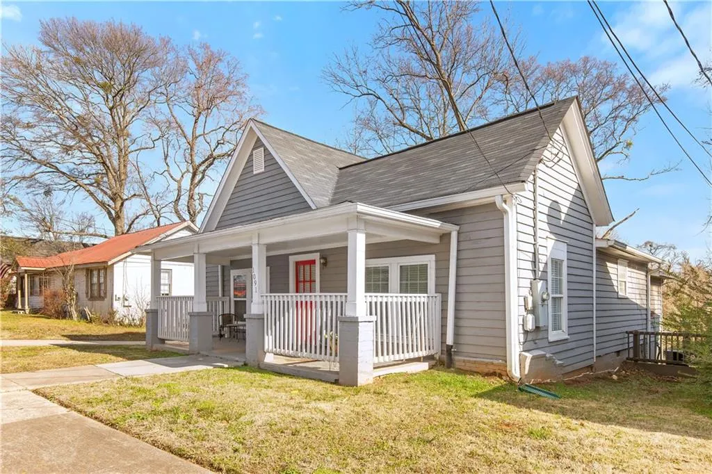 Bungalow with covered porch and a front lawn
