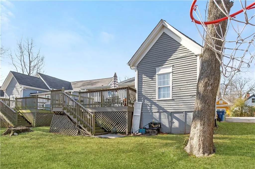 Rear view of property featuring a yard and a wooden deck
