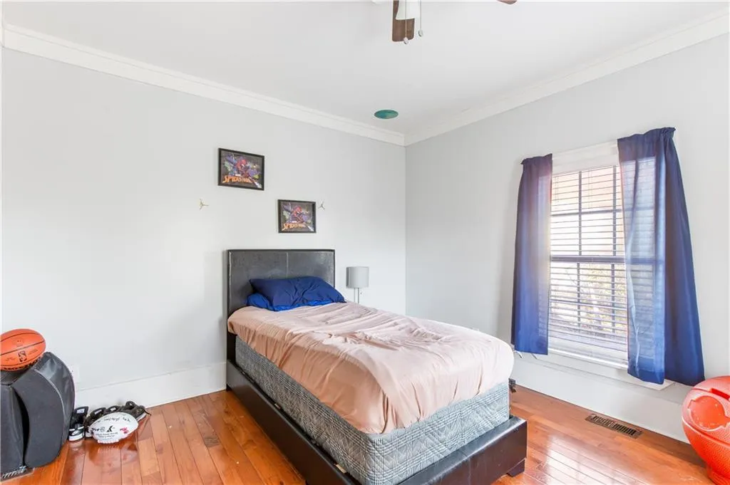 Bedroom featuring crown molding, light hardwood / wood-style flooring, and ceiling fan