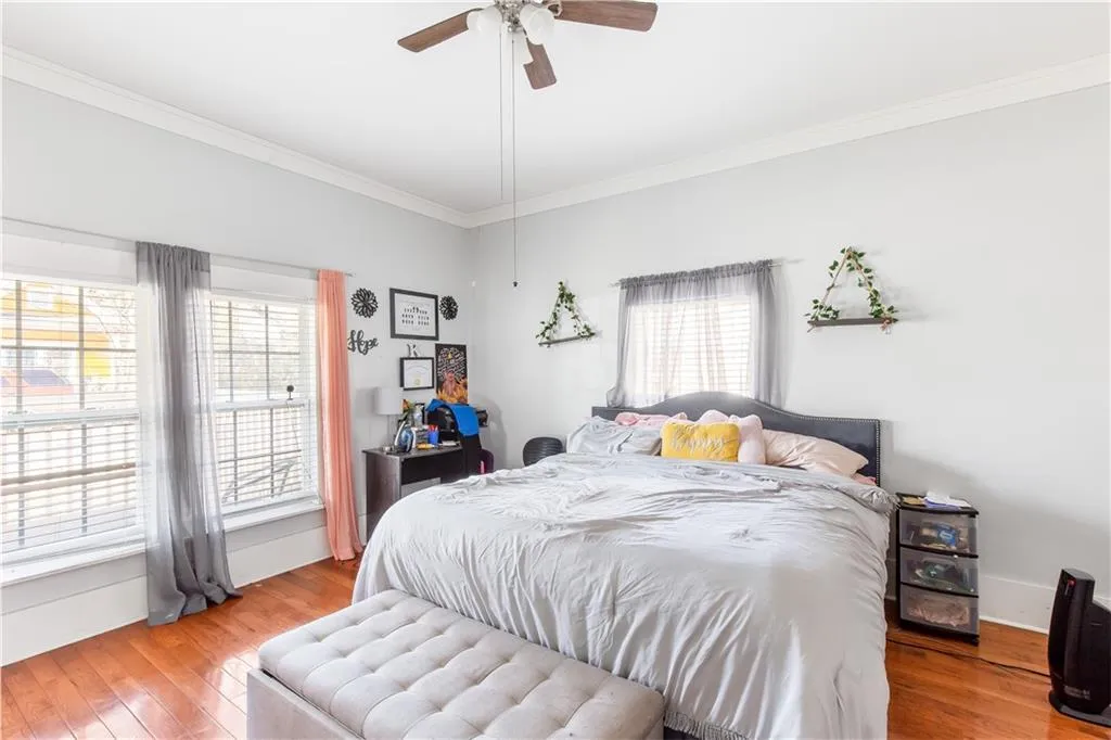 Bedroom with crown molding, light hardwood / wood-style floors, and ceiling fan