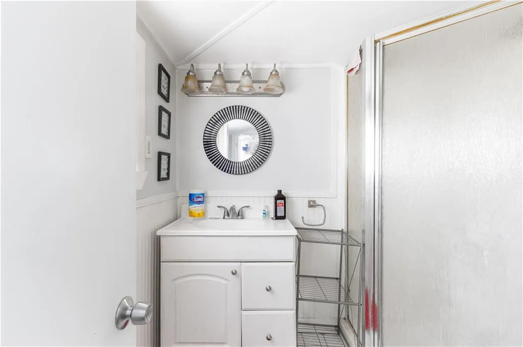 Bathroom featuring a shower with shower door, tile floors, and vanity
