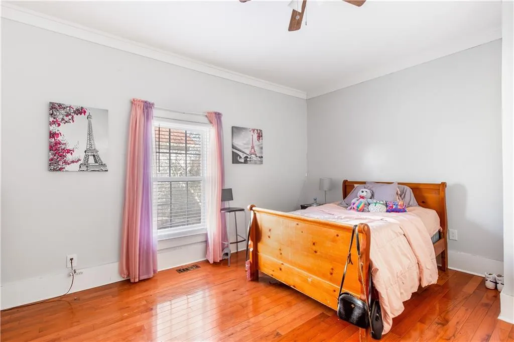 Bedroom with crown molding, light wood-type flooring, and ceiling fan