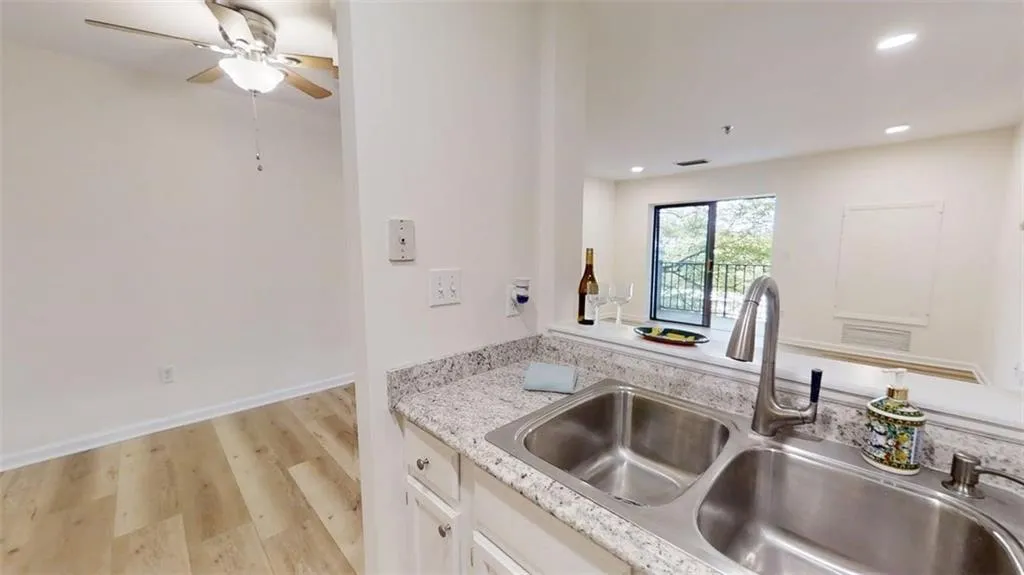 Kitchen with light wood-style flooring, white cabinetry, ceiling fan, and recessed lighting