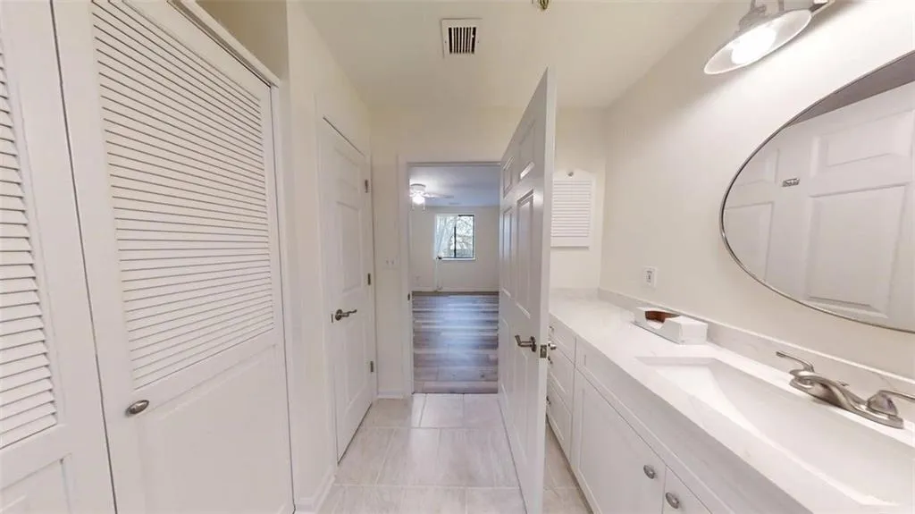 Bathroom featuring a closet, vanity, and light tile patterned flooring