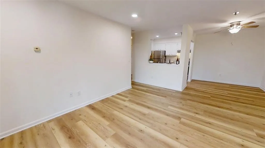 Unfurnished living room featuring light wood finished floors, a ceiling fan, and recessed lighting