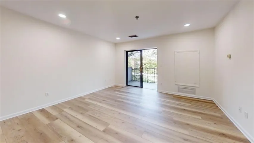 Empty room with light wood-type flooring and recessed lighting