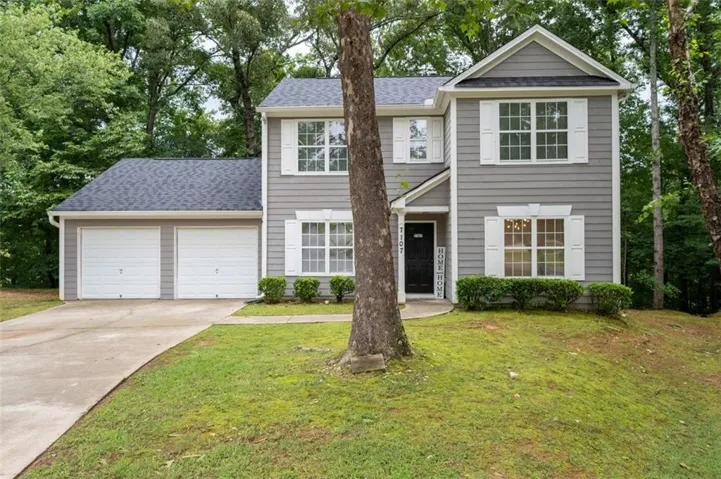 Contemporary two-story exterior with gray siding, white window shutters, and a dark shingle roof