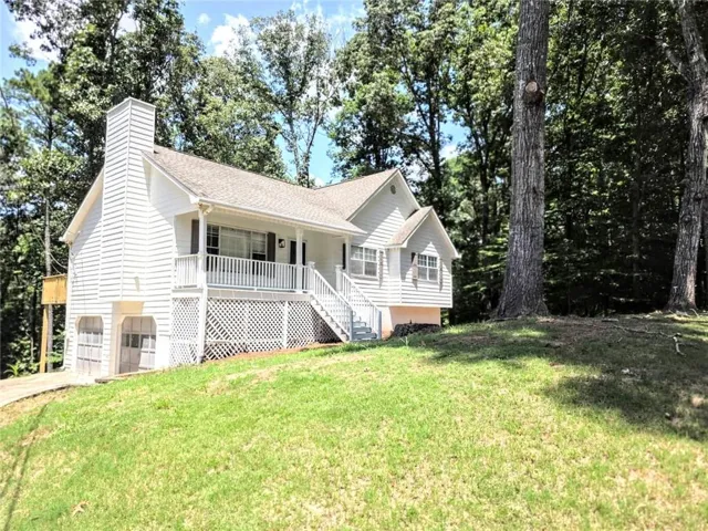 Split-level residence featuring white siding and a prominent front porch with white railings