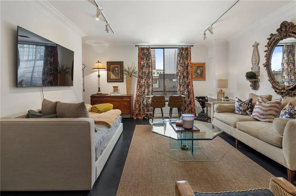 Living room with wood finished floors, plenty of natural light, ornamental molding, and rail lighting